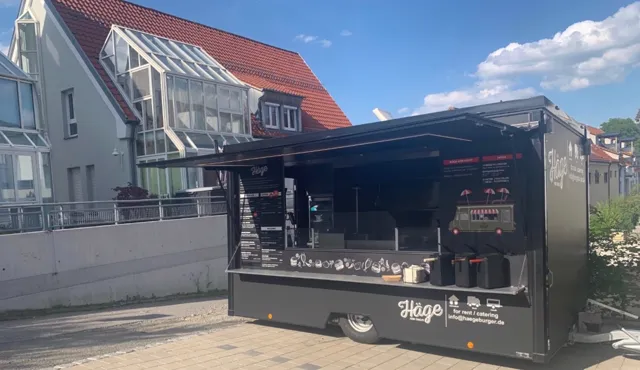 Schwarzer Häge-Foodtrailer mit aufgeklappter Theke