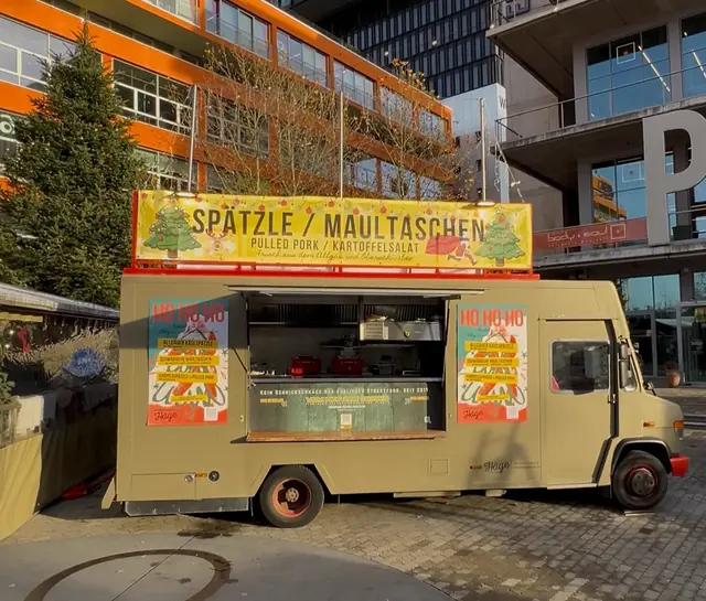 Olivfarbener Häge-Foodtruck mit Spätzle- und Maultaschen-Banner im Münchner Werksviertel